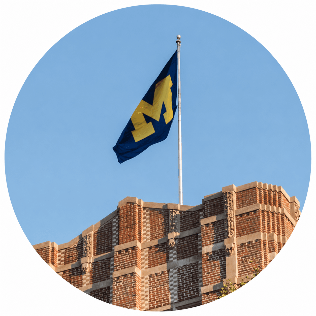 University of Michigan flag flying above a campus building